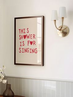 a bathroom with a sink, mirror and framed art on the wall next to it