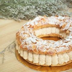 a round cake sitting on top of a wooden table covered in powdered sugar and banana slices