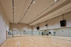 an empty dance hall with wooden floors and lights hanging from the ceiling in front of them