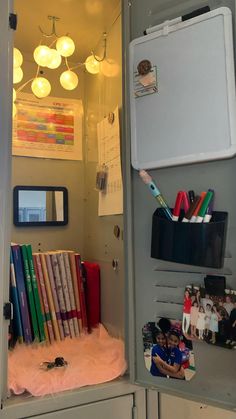 an open locker with many books, pens and pencils in it's door