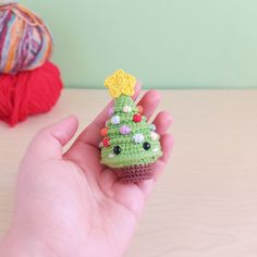 a hand holding a tiny crocheted christmas tree