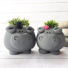 two gray ceramic hippo planters sitting next to each other