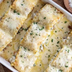 a casserole dish filled with cheese and meat on top of a wooden table