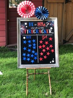 a chalkboard sign with stars on it in front of a red, white and blue pinwheel