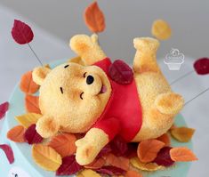 a winnie the pooh cake with leaves on it