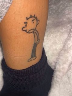 a person with a tattoo on their leg that has a cartoon character drawn on it