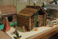 a gingerbread house made out of sticks on a table