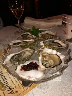 an oyster platter on a table with wine glasses