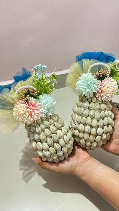 two vases made out of shells and flowers