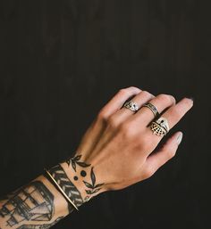 a person's hand with two rings on their fingers and one ring in the middle