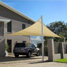 a car parked in front of a house with an awning on the side of it