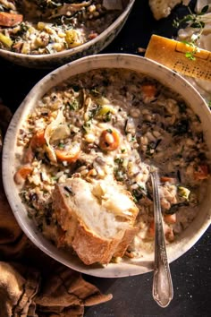 two bowls filled with soup and bread on top of a table