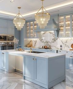 a large kitchen with blue cabinets and marble counter tops, chandelier above the island