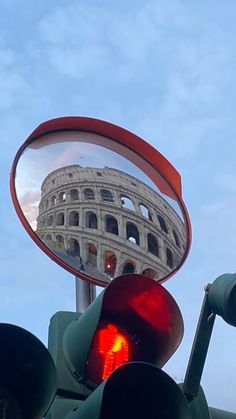 a traffic light with a reflection of the colossion in it's rear view mirror