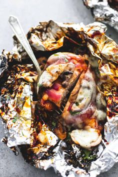 a close up of food on tin foil with a knife and fork in the middle