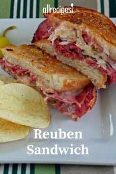 a sandwich and chips on a plate with the words reuben sandwich written in white letters