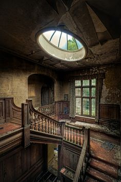 an abandoned house with stairs and windows