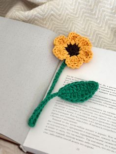 a crocheted flower sitting on top of an open book