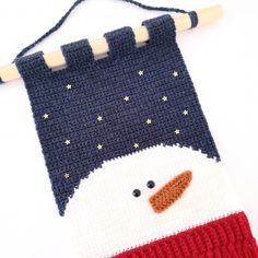 a crocheted christmas stocking with a snowman face on it's side