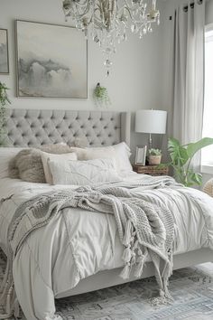 a bedroom with a bed, chandelier and pictures on the wall above it