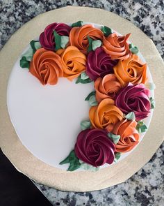 there is a white cake with orange and red flowers on it