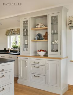 a kitchen with white cabinets and wooden floors