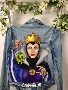 a jean jacket with an image of the evil queen holding a skull and wearing a crown