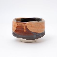 a brown and black bowl sitting on top of a white table