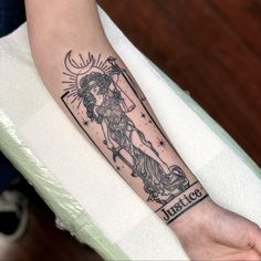 a woman's arm with a tattoo on it that reads just god and is holding a cross