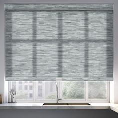 a kitchen window with roman blinds in shades of grey and white, next to a sink