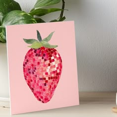 a strawberry with pink and red mosaic tiles on it's side, sitting next to a potted plant