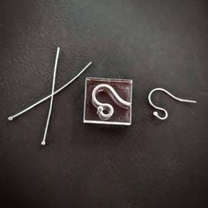 a piece of metal sitting on top of a black table next to some wires and hooks