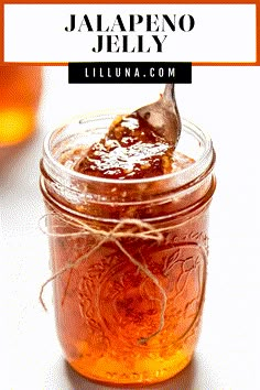 a jar filled with honey sitting on top of a table next to a wooden spoon