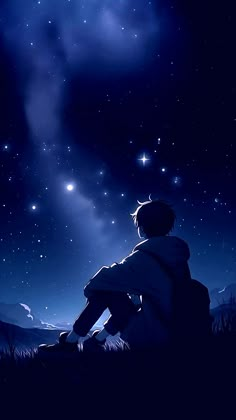 a person sitting in the grass looking up at the stars