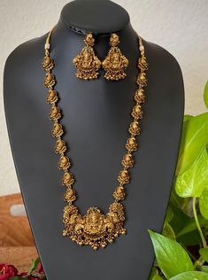 An elegant set for your local gatherings or parties. The length of the antique kemp AD haram is given in one of the pictures. Measurements of the jhumkas. Height: 5.5 Cm  Width : 3.5 Cm  Care Instruction : Avoid Heat & Chemicals Like Perfume, Deo, Alchol, Etc. | Clean With Dry Cotton Cloth | Pack In our Anti tarnish box after use. 56 Grams Gold Haram Designs, Lakshmi Haar Gold, Long Temple Jewellery Necklace, Luxury 22k Gold Hallmarked Temple Necklace, Luxury Gold Temple Jewelry Beads, Temple Jewelry Necklace With Peacock Design For Rituals, Temple Necklace With Peacock Design For Rituals, Gold Temple Necklace With Peacock Design For Wedding, Antique Gold Heavy Temple Necklace