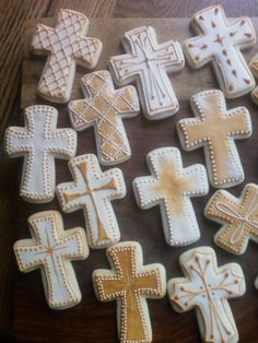 many decorated cookies with crosses on them are sitting on a wooden table and ready to be eaten