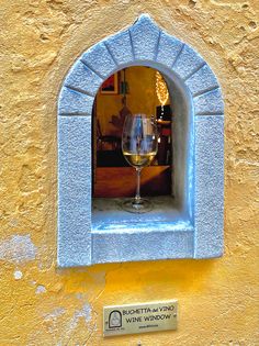 a glass of wine sitting on top of a window sill