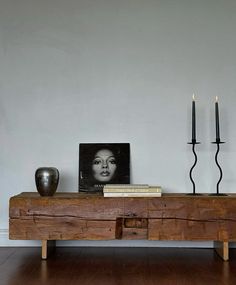 a wooden table with two candles on top of it and a framed photograph next to it