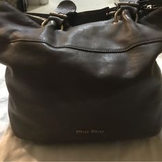 Very Cute Miu Miu Cray Hand Bag. Very Roomy With Gold Detailing. One Hand Area Has Its Stitches Coming Out Doesn’t Affect Its Use. Authentic And Classic. Please Look Through The Pictures Before Buying. Miu Miu Shoulder Bag With Adjustable Strap For Travel, Designer Gray Bag With Removable Pouch, Chic Gray Shoulder Bag With Dust Bag, Gray Leather Shoulder Bag With Detachable Handle, Miu Miu Travel Tote Shoulder Bag, Miu Miu Tote Shoulder Bag For Travel, Miu Miu Shoulder Bag For Travel, Miu Miu Everyday Satchel Shoulder Bag, Miu Miu Crossbody Travel Bag