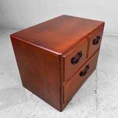 a wooden box with two drawers on it