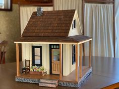 a doll house sitting on top of a wooden table