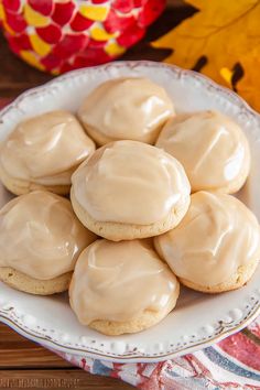 a white plate topped with cookies covered in frosting on top of a wooden table