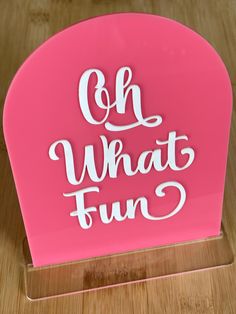 an acrylic sign that says oh what fun in white letters on a pink background