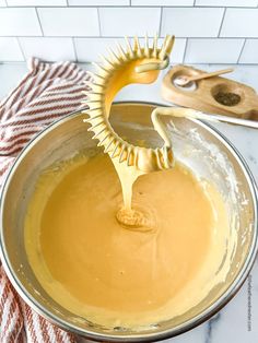 a metal bowl filled with batter on top of a counter