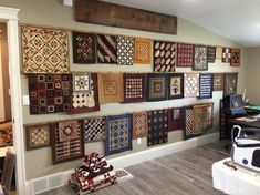 a room filled with lots of quilts on the wall