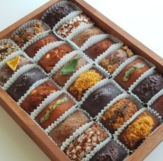 a wooden box filled with lots of different types of desserts on top of each other