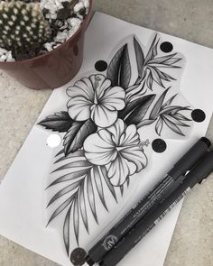 some flowers are drawn on paper next to a potted plant