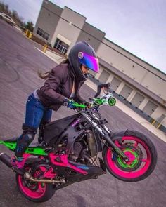 a person on a motorcycle doing tricks in the parking lot with his helmet and goggles on