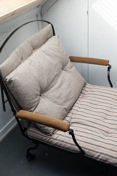 a futon bed sitting on top of a floor next to a wooden table and window