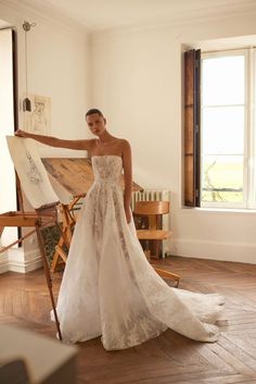 a woman standing in front of an easel